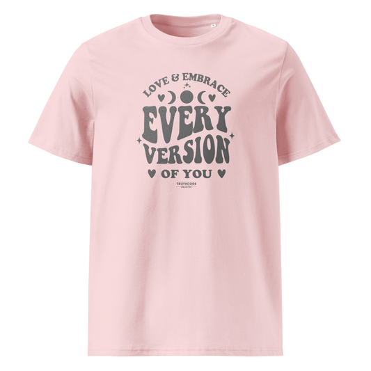 Pink organic t-shirt with motivational text 'Love & embrace every version of you' on a white background