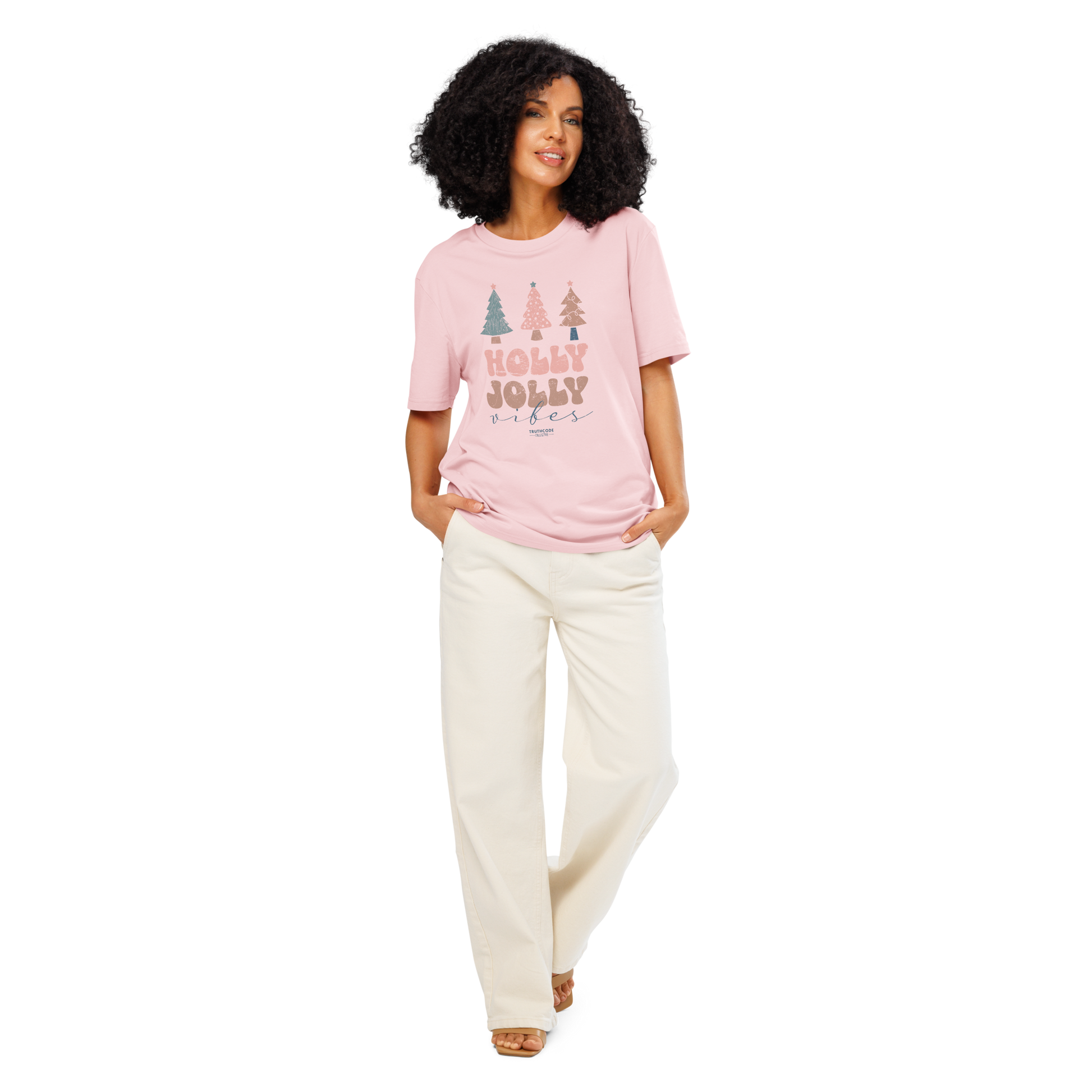 Woman wearing a pink 'Merry Jolly Vibes' t-shirt and white pants on a white background