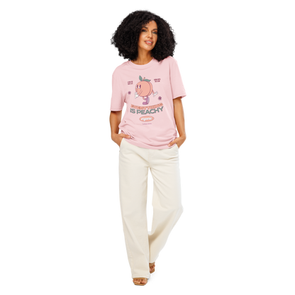 Woman wearing pink organic t-shirt with a cartoon peach character and text 'Everything is peachy' on a white background