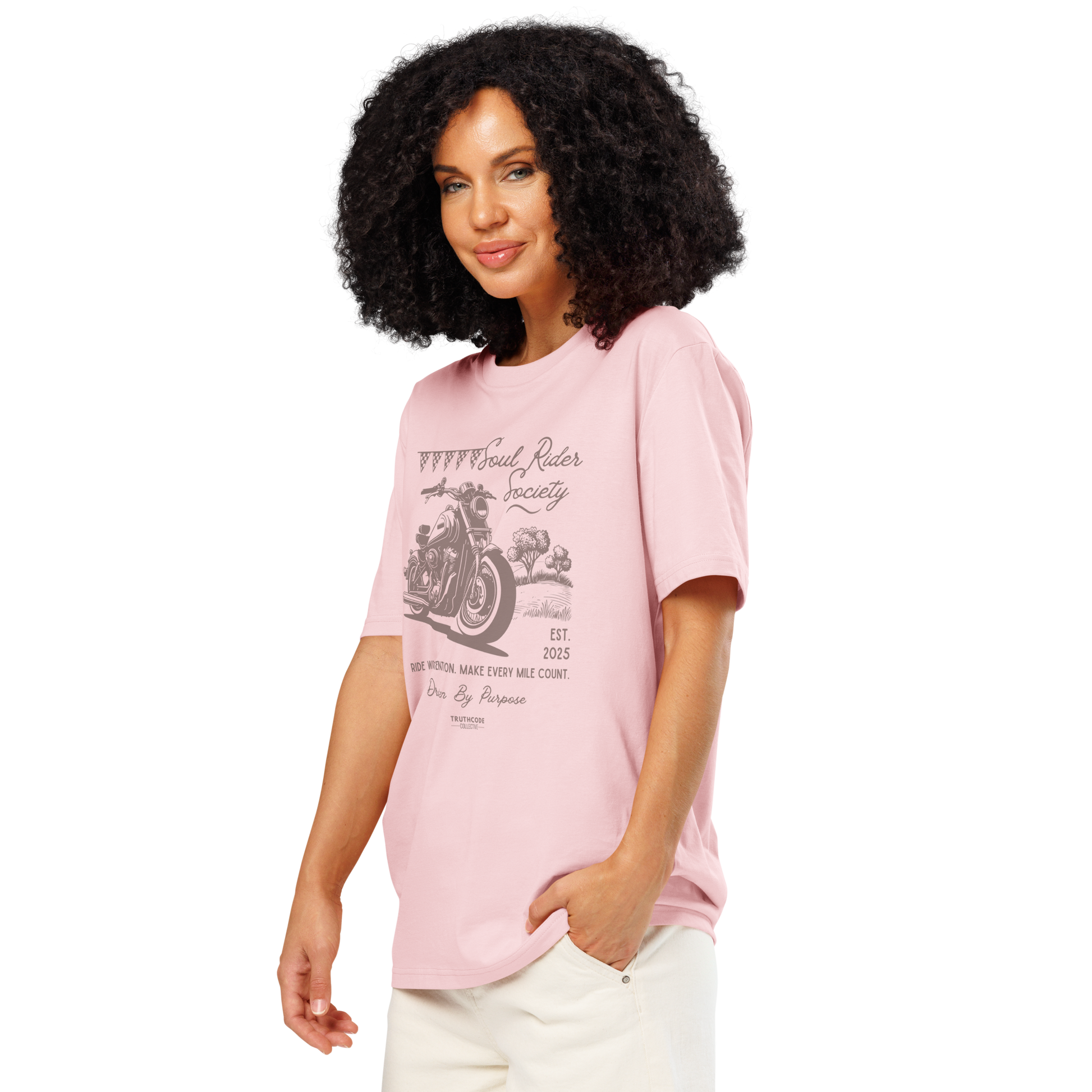 Woman wearing pink organic t-shirt with motorcycle graphic and text 'Soul rider society, ride with intention, make every mile count' on a white background