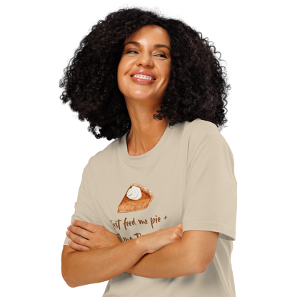 Woman wearing beige organic t-shirt with a pie graphic and text 'Just feed me pie + tell me I'm pretty'