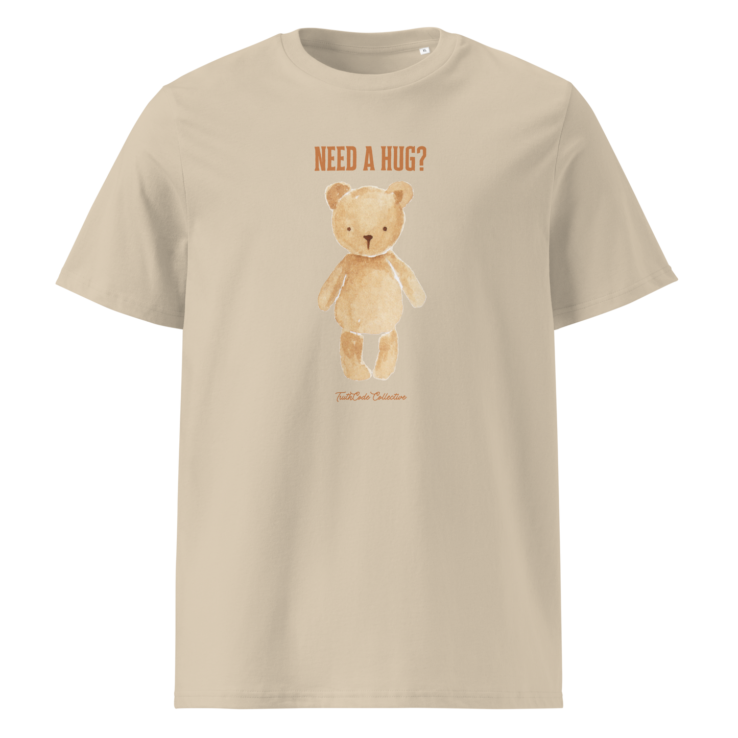 Beige organic t-shirt with a teddy bear graphic and text 'NEED A HUG?' on a white background