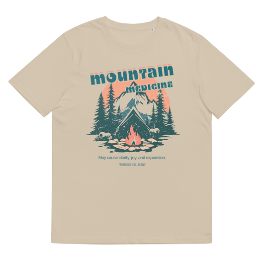 Beige organic t-shirt with mountain and forest graphic and text 'Mountain Medicine, may cause clarity, joy, and expansion', shirt on a white background