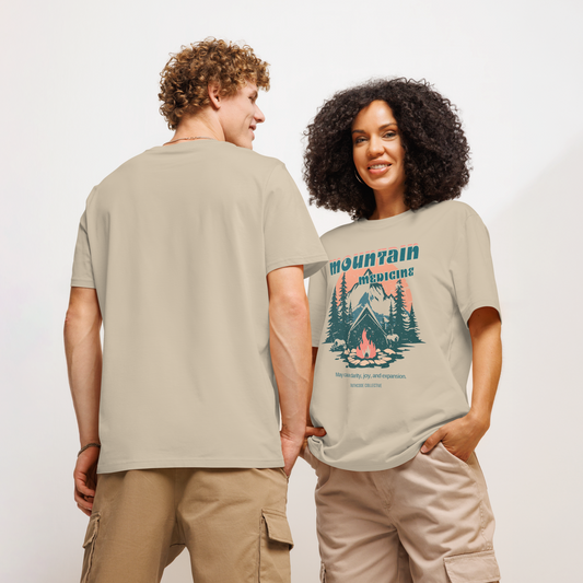 Models wearing beige organic t-shirt with mountain and forest graphic and text 'Mountain Medicine, may cause clarity, joy, and expansion', on a white background