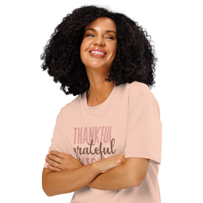 Woman wearing peach organic t-shirt with 'Thankful grateful BLESSED' text design on a white background