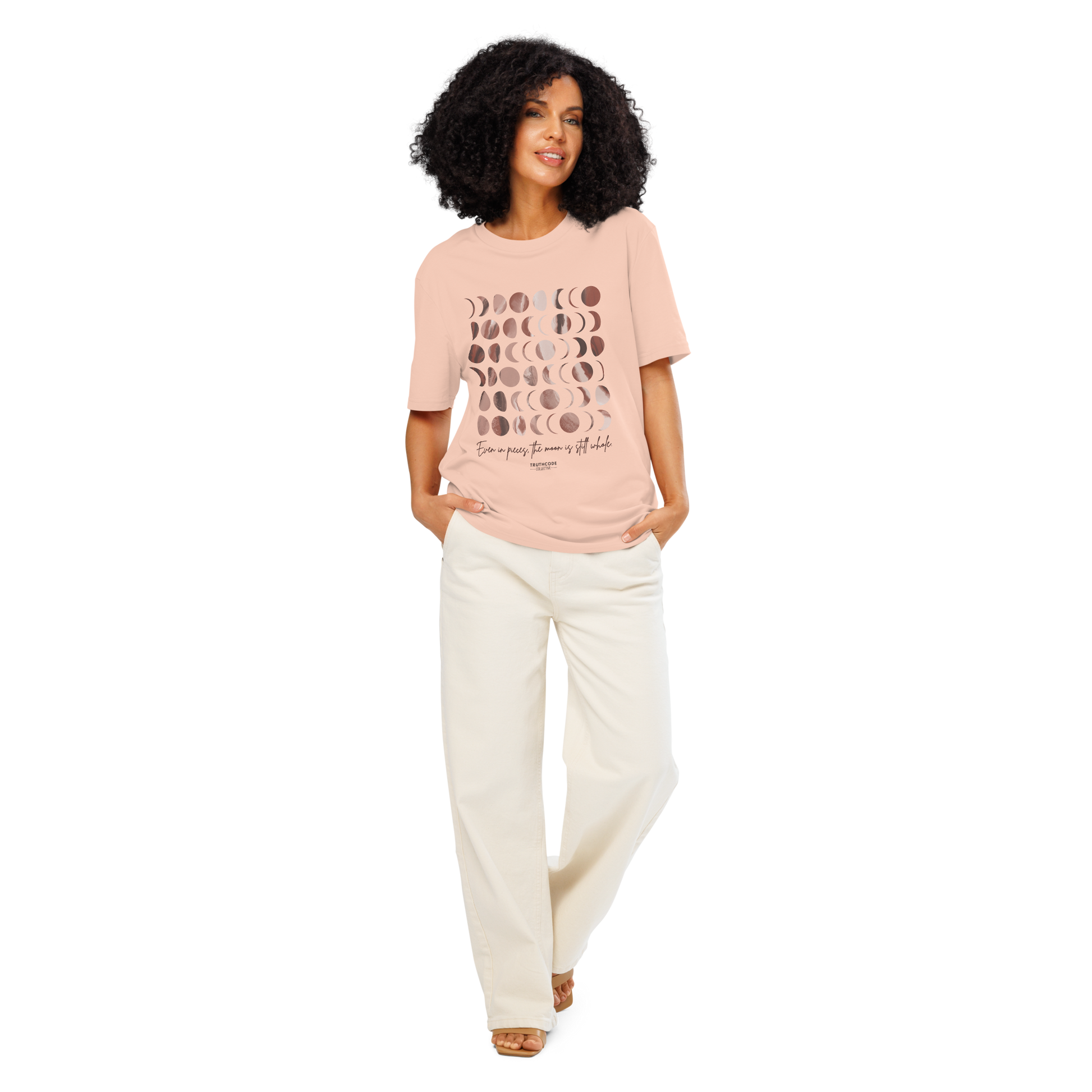 Woman wearing peach organic t-shirt with rose gold moon phase design and text 'Even in pieces, the moon is still whole' on a white background