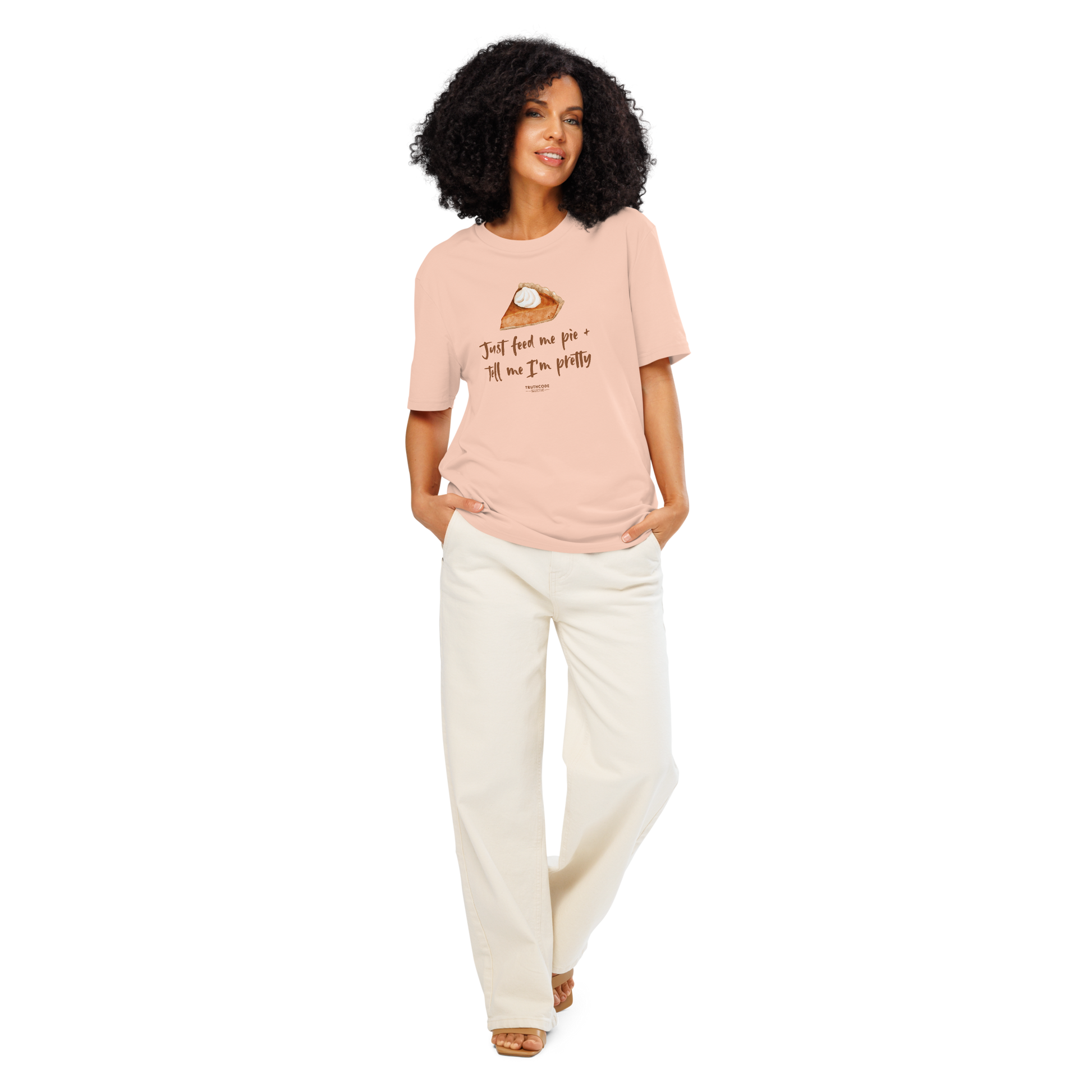 Woman wearing peach organic t-shirt with a pie graphic and text 'Just feed me pie + tell me I'm pretty' on a white background