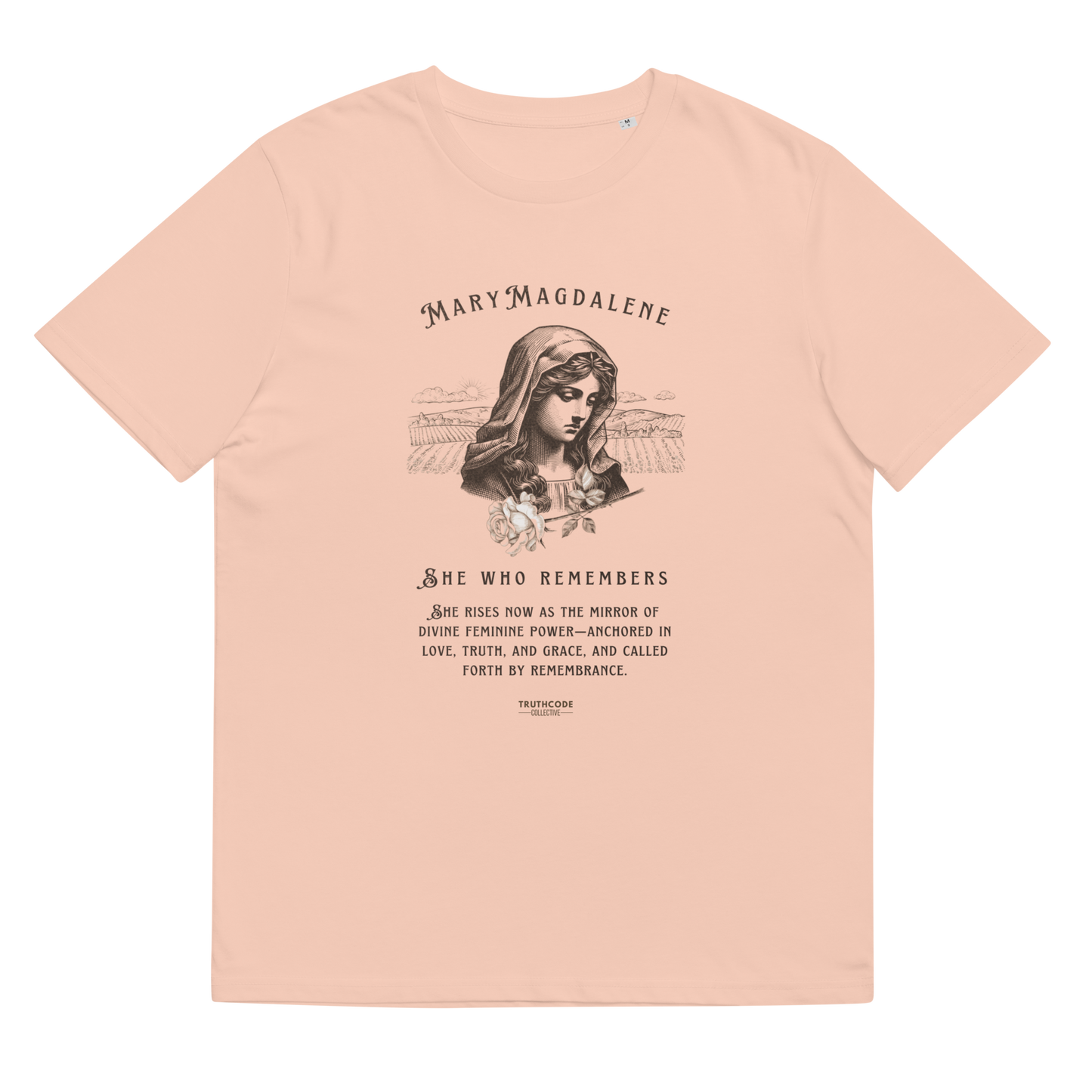 Peach organic t-shirt with a graphic of Mary Magdalene and text 'She who remembers, she rises now as the mirror of the divine feminine power...',  on a white background