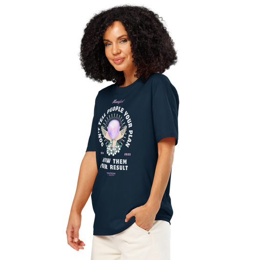 Woman wearing navy blue organic t-shirt with graphic design of hands holding a magic ball  and text 'Don't tell people your plan, show them your result' on a white background