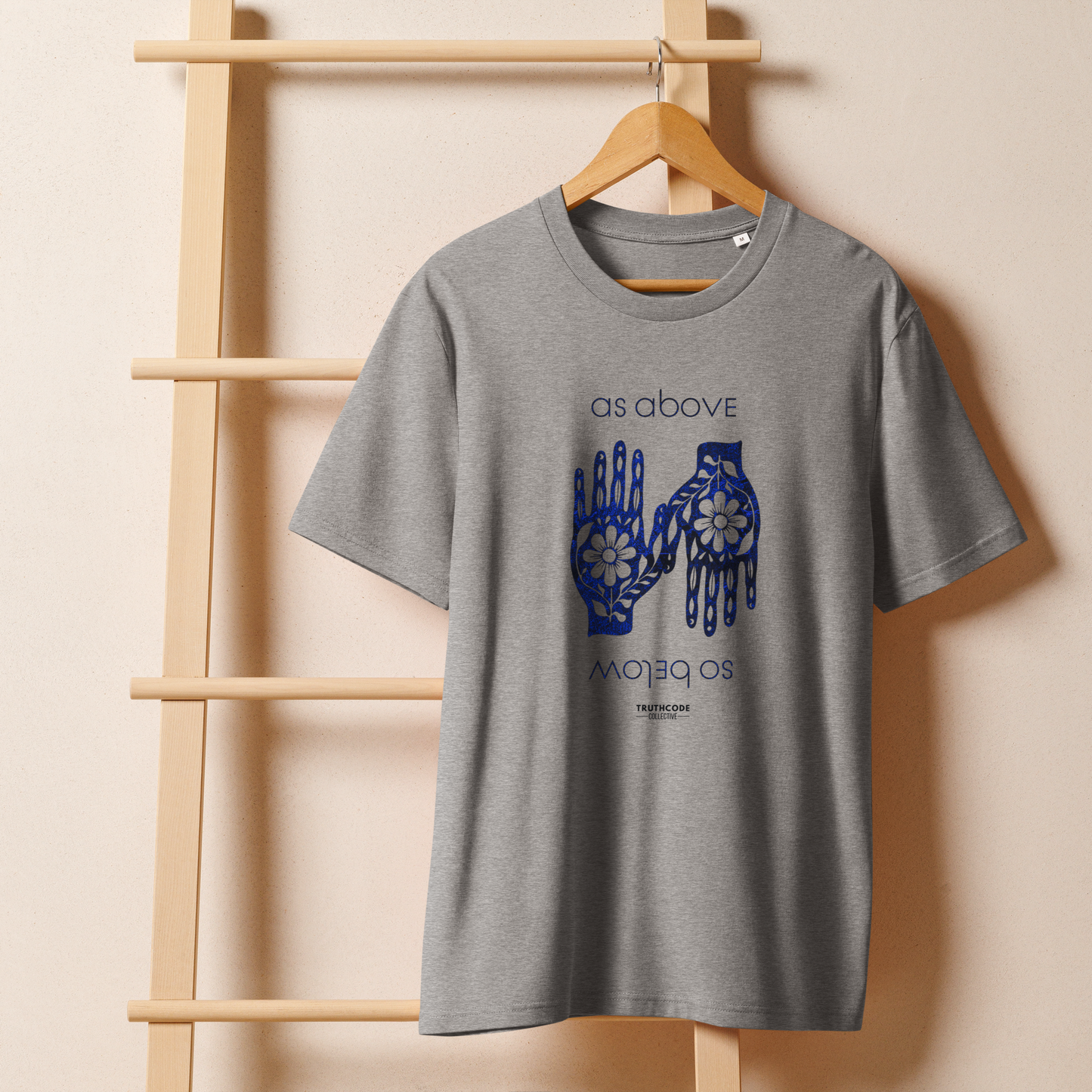 Gray organic t-shirt with blue text 'as above so below' and a graphic of hands with flowers on a white background