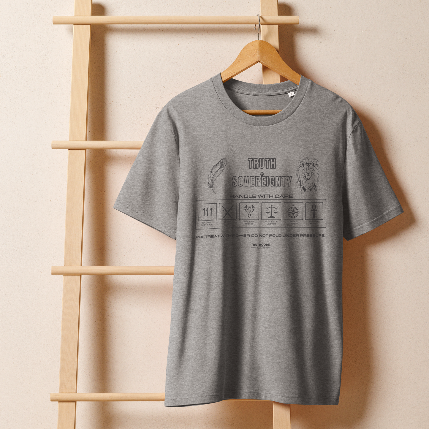 Gray organic t-shirt with text 'Truth + Sovereignty' with symbols and graphics relating to it on a white background