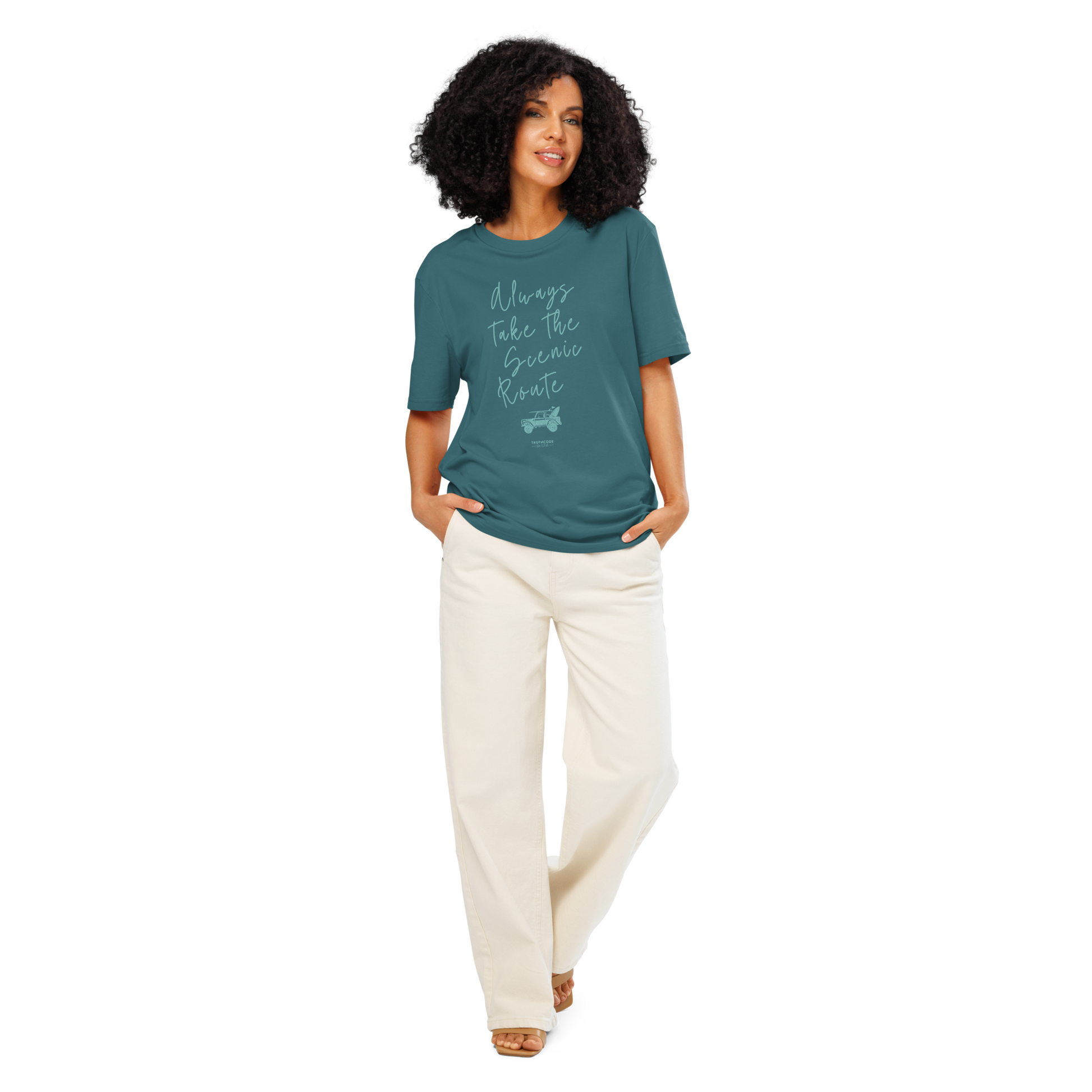 Woman wearing teal organic t-shirt with text design 'Always take the scenic route' with truck with surf board graphic on a white background