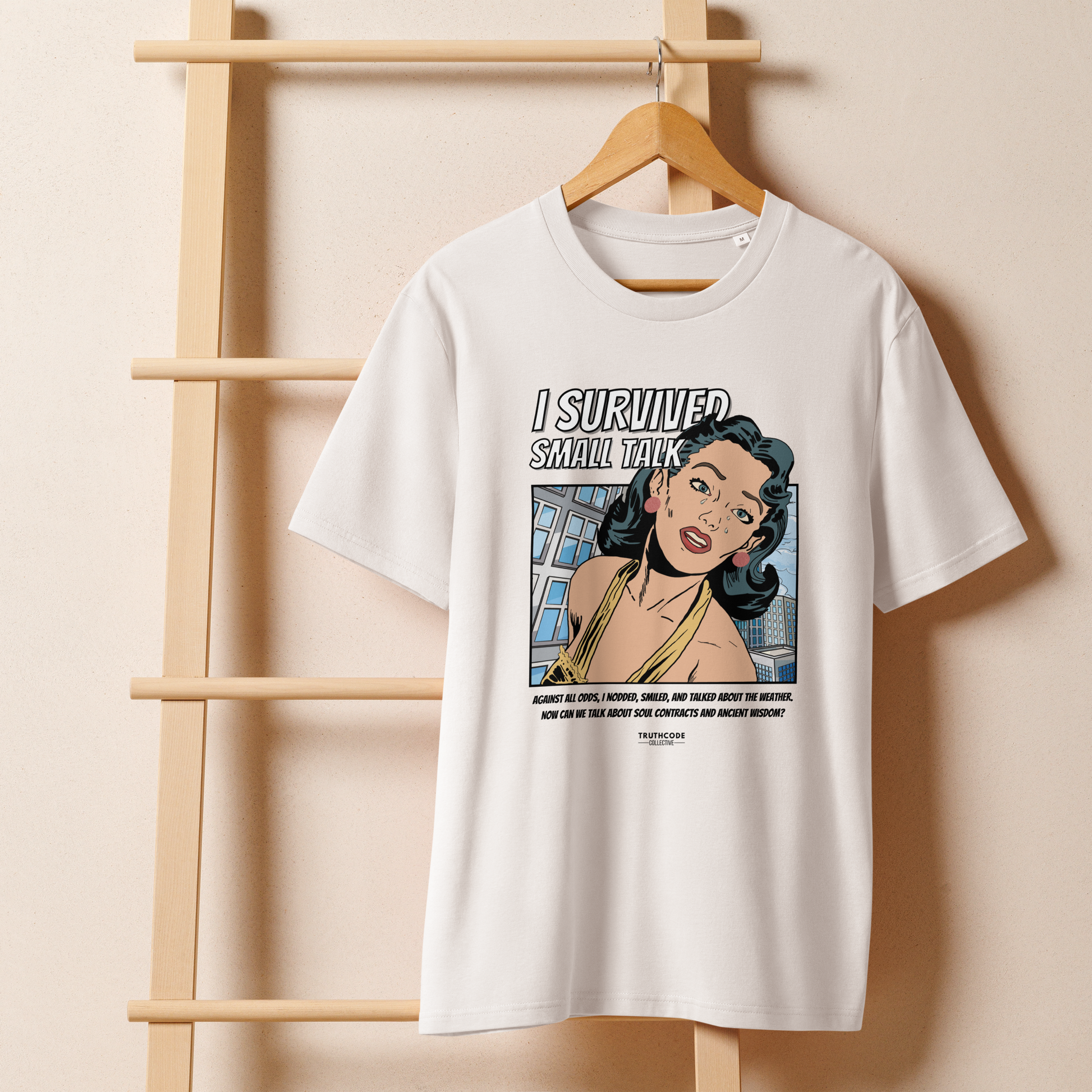 White organic t-shirt with a graphic design featuring a comic cartoon woman and text with lighthearted saying 'I SURVIVED SMALL TALK'