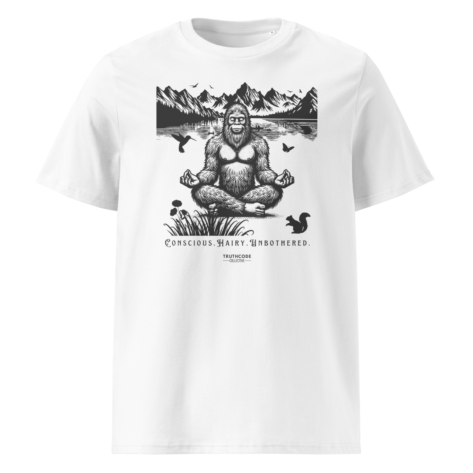 White organic t-shirt with a graphic of a meditating Sasquatch in a mountain setting and text reading 'Conscious, hairy, and unbothered' 