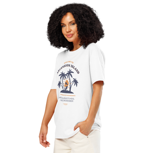 Woman wearing white organic t-shirt with palm tree design and text 'Ascension island, where sunsets heal + stars remember' on a white background