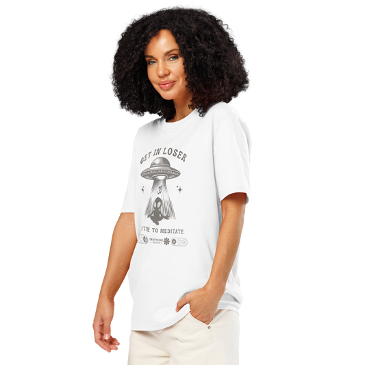 Woman wearing white organic t-shirt with a graphic design featuring a UFO and text 'Get in loser, it's time to meditate' on a white background