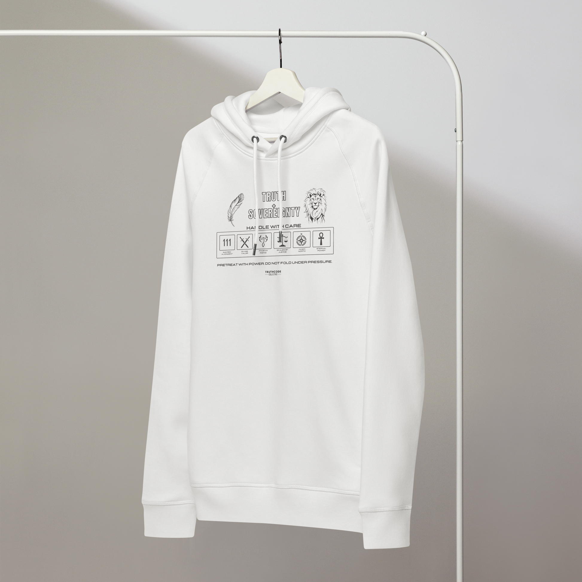White organic hoodie with text 'Truth + Sovereignty' with symbols graphics relating to it on a white hanger with a gray wall background