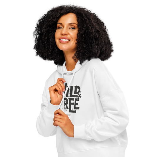 Woman wearing white organic hoodie with 'Wild & Free' text design, on a white background